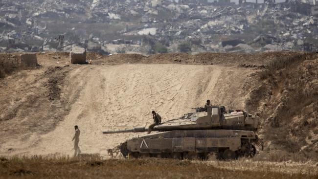 Israeli soldiers sit on a tank near the border with the Gaza Strip. Picture: Getty