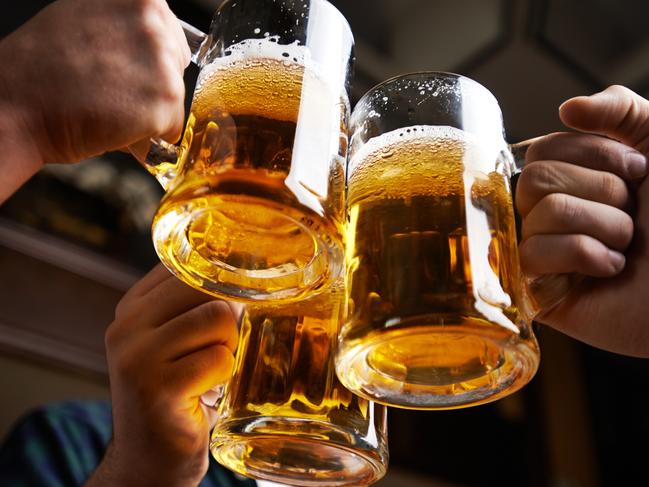 Hands of three men toasting with beer