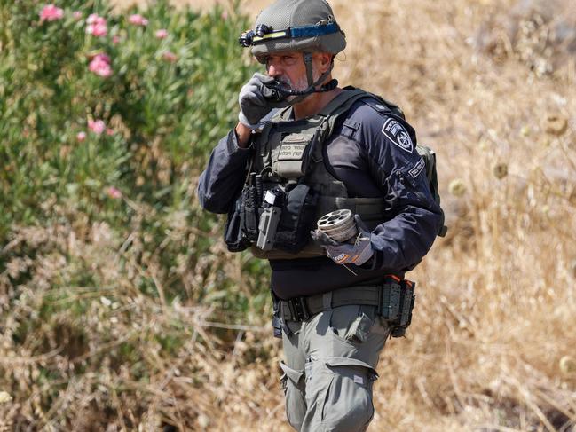 A member of Israeli security forces inspects remnants of rockets launched from southern Lebanon which fell in Kiryat Shmona in northern Israel near the Lebanon border. Picture: AFP