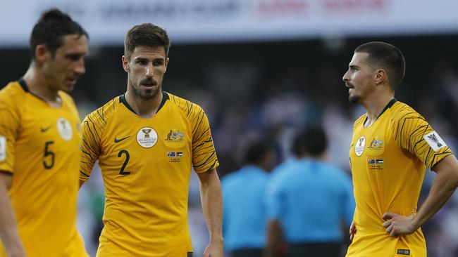 Australia's midfielder Mark Milligan, defender Milos Degenek and forward Jamie Maclaren, from left, walk along the pitch at the end of the AFC Asian Cup group B soccer match between Australia and Jordan at Hazza bin Zayed stadium in Al Ain, United Arab Emirates, Sunday, Jan. 6, 2019. Jordan won 1-0. (AP Photo/Hassan Ammar)