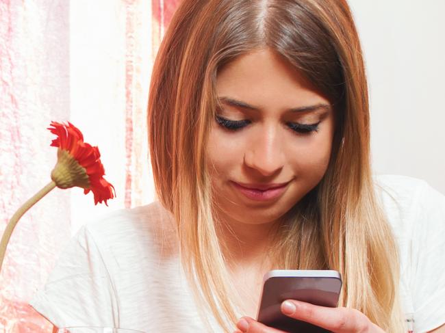 Girl texting on the phone during breakfast