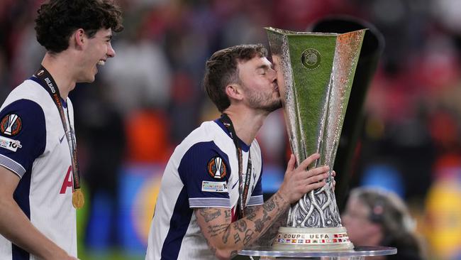 Tottenham Hotspur's James Maddison kisses the trophy after missing the final through injury. (AP Photo/Manu Fernandez)