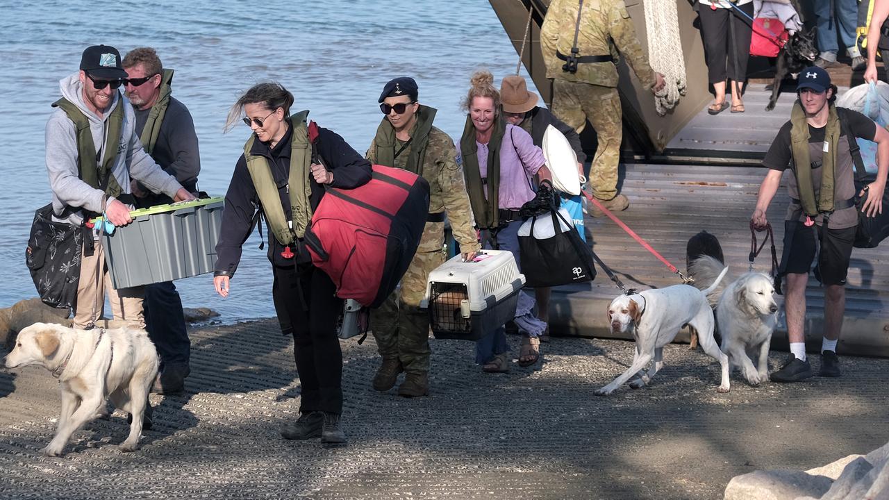 Families and their pets evacuated from the Victorian coastal town of Mallacoota arrive in Hastings on the Mornington Peninsula on Wednesday. Picture: Luis Ascui/Getty