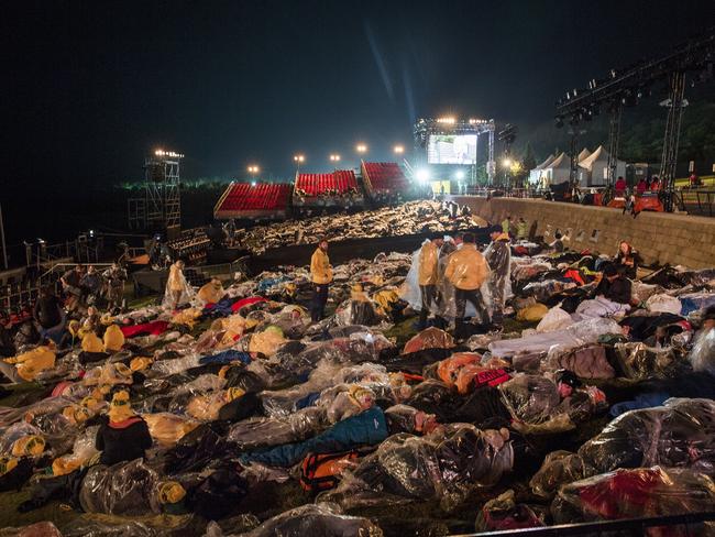 Around 1000 people wait for the dawn service in Anzac Cove wrapped in plastic ponchos after rain poured earlier in the evening. Picture: Ella Pellegrini