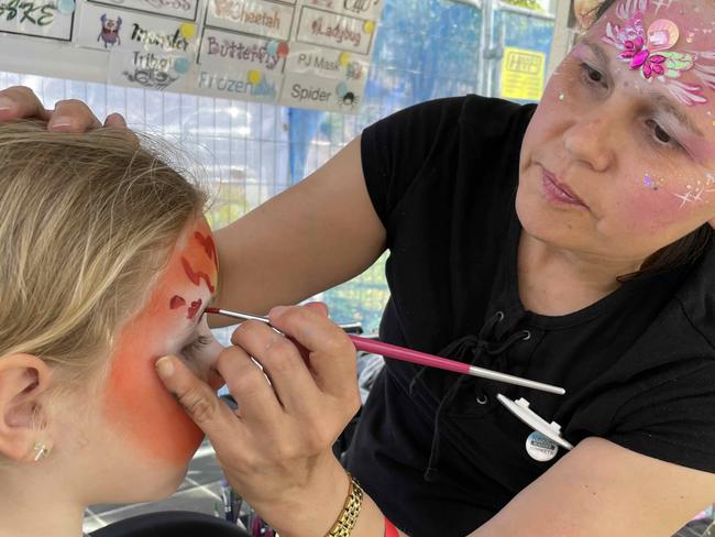 Venera paints a tiger on the face of Emma at the Fraser Coast Flavours Festival at Seafront Oval on September 1, 2023.