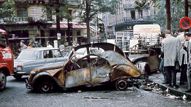 On May 25, 1968, Parisians look at vehicles set alight the night before during scuffles between students and police. Picture: AFP