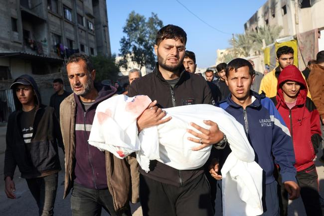 A relative in Khan Yunis, southern Gaza, carries the body of a child -- Civil Defence rescuers said an Israeli strike killed at least five members of one family