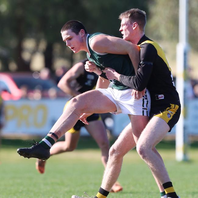 Echuca’s Hugh Byrne gets his kick away despite pressure from Rochester’s Ryan O'Keefe.