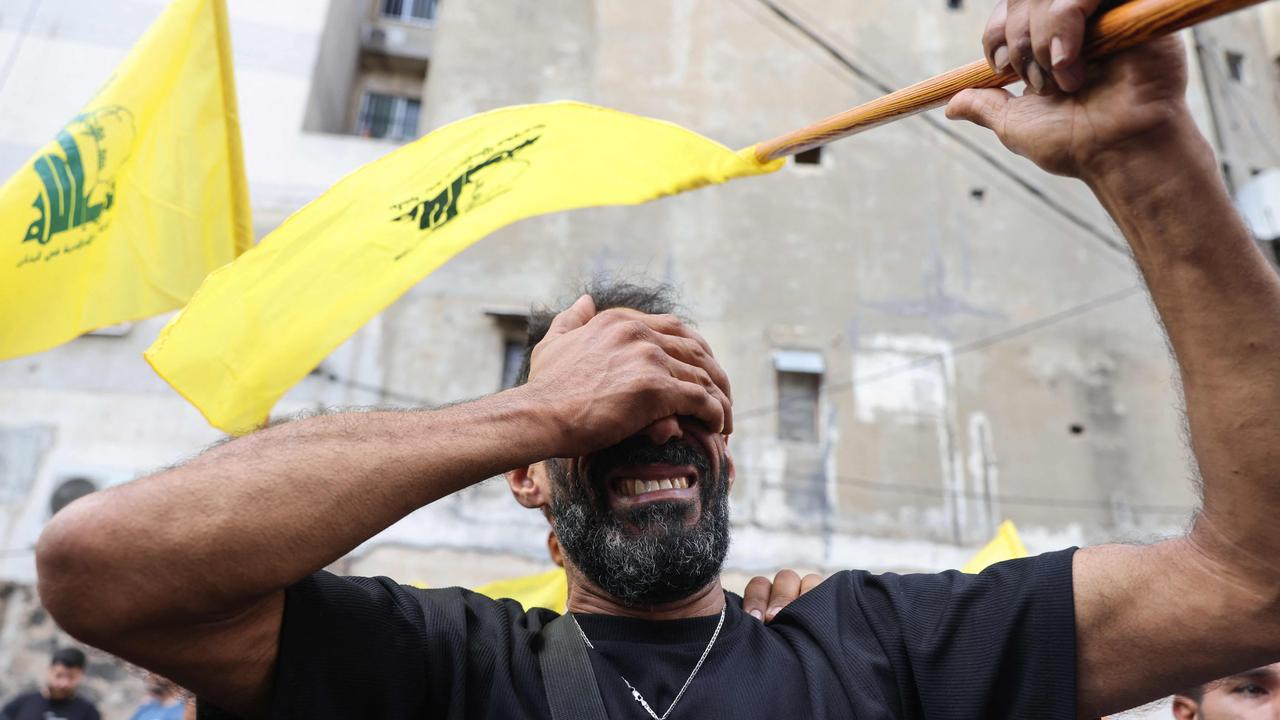 A man reacts while holding a Hezbollah flag during the funeral of people killed after hundreds of paging devices exploded in a deadly wave across Lebanon. Picture: Anwar Amro/AFP