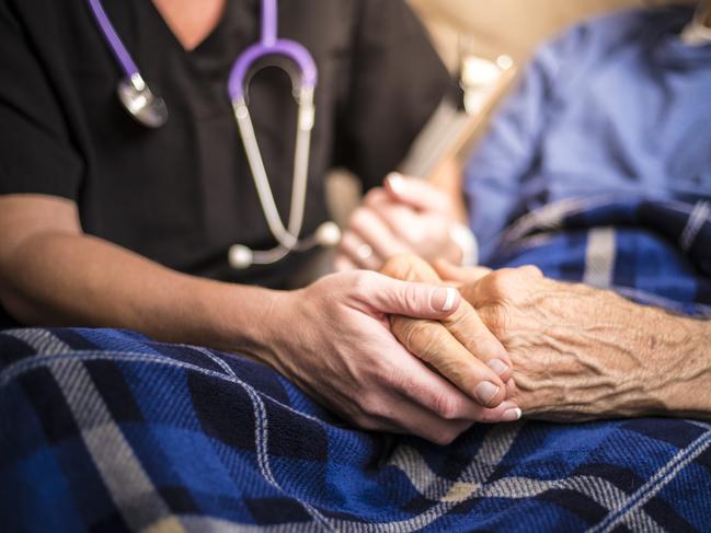 A stock photo of a Hospice Nurse visiting an Elderly male patient who is receiving hospice/palliative care.