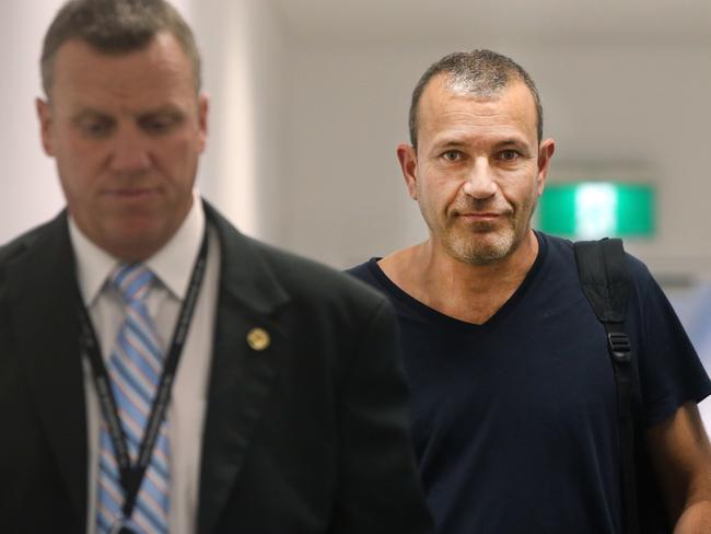 Albert escorted by police at Sydney International Airport in 2017. Picture: Richard Dobson