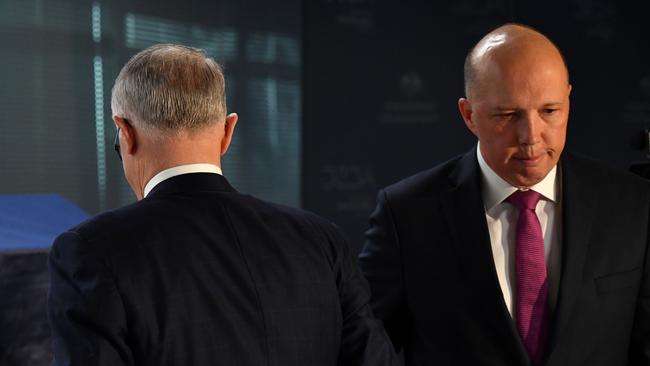 Prime Minister Malcolm Turnbull and Minister for Home Affairs Peter Dutton pass each other yesterday.