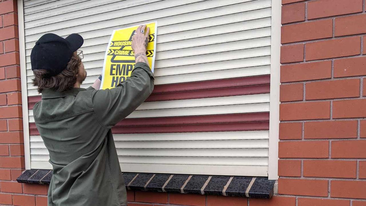 Mr van den Lamb affixes one of the campaign stickers onto a home.