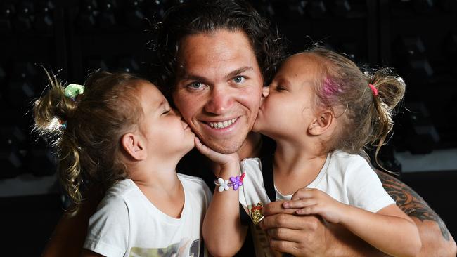 2019 NTFL Nichols medalist Phillip Wills at the Michael Long Centre, with his daughters Sophie (three) and Stella (four). Picture: Katrina Bridgeford