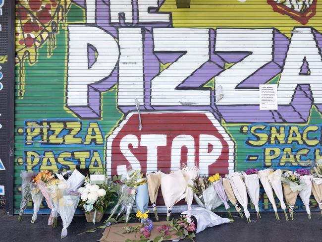 Flowers left outside the pizza shop after the owner was stabbed to death in Kingswood following an alleged dispute over a can of coke. Picture: Ted Lamb.