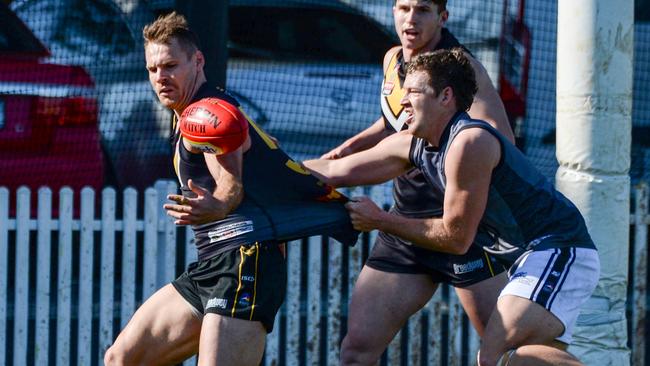 Port District’s Luke McInerney tackles Brighton’s Nigel Osborn during division one play last season. Kernahan said the last possession rule may continue to higher grades in 2023 if popular. Picture: Brenton Edwards