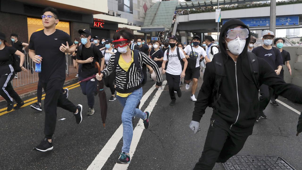 Protesters run near the Legislative Council. Picture: Kin Cheung/AP