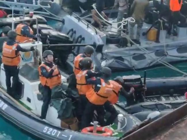 This frame grab from handout video taken on June 17, 2024 and released by the Armed Forces of the Philippines Public Affairs Office on June 19 shows a China coast guard member (C) appearing to try to puncture a Philippine inflatable boat with a weapon during an incident off Second Thomas Shoal in the South China Sea. The Philippine military said on June 19 the Chinese coast guard rammed and boarded Filipino navy boats in a violent confrontation in the South China Sea this week in which a Filipino sailor lost a thumb. China defended its actions, with its foreign ministry saying on Wednesday that "no direct measures" were taken against Filipino personnel. (Photo by Handout / ARMED FORCES OF THE PHILIPPINES-PUBLIC AFFAIRS OFFICE / AFP) / -----EDITORS NOTE --- RESTRICTED TO EDITORIAL USE - MANDATORY CREDIT "AFP PHOTO / ARMED FORCES OF THE PHILIPPINES - PUBLIC AFFAIRS OFFICE" - NO MARKETING - NO ADVERTISING CAMPAIGNS - DISTRIBUTED AS A SERVICE TO CLIENTS