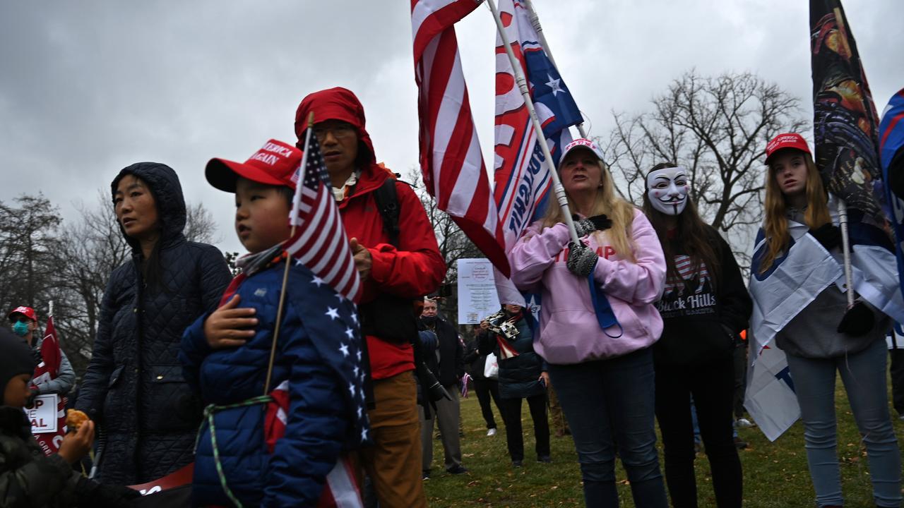 Supporters of US President Donald Trump say the pledge of allegiance as they gather on Capitol Hill January 5, 2021, in Washington, DC, to protest the upcoming electoral college certification on January 6 of Joe Biden as President. (Photo by Brendan Smialowski / AFP)