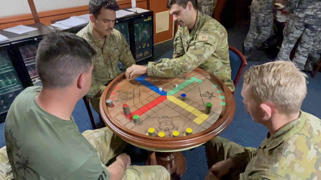 Down time on HMAS Canberra sees personnel in the Officers' mess ward room play Uckers. Picture: Charles Miranda