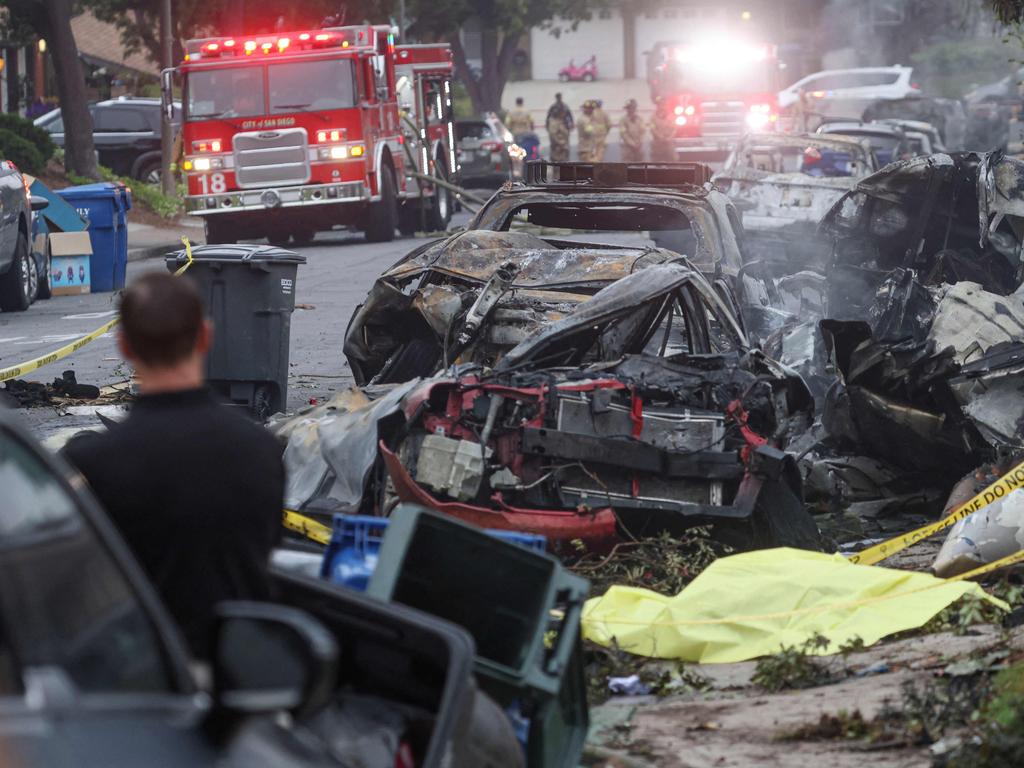 Investigators look through the site where a small plane crashed on a San Diego, California, residential street. Picture: AFP