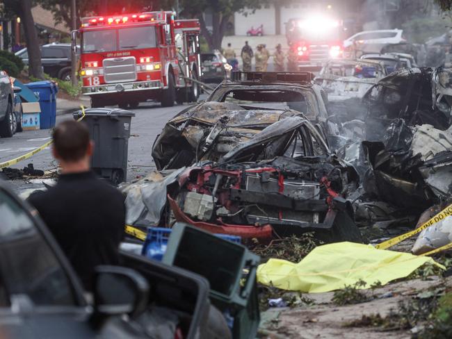 Investigators look through the site where a small plane crashed on a San Diego, California, residential street. Picture: AFP