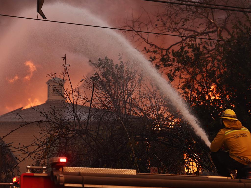 A firefighter sprays burning home during the Eaton fire in Altadena. Picture: Mario Tama/Getty Images/AFP