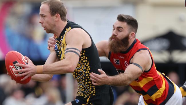 Glenelg’s Alex Martini is tackled by Crow Isaya McKenzie at the Bay Oval on Saturday. Picture: SANFL Image/David Mariuz.