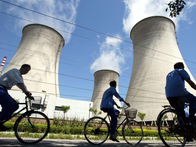 Cyclist riding past cooling towers of nuclear power station in Beijing, China 04 Aug 2004.