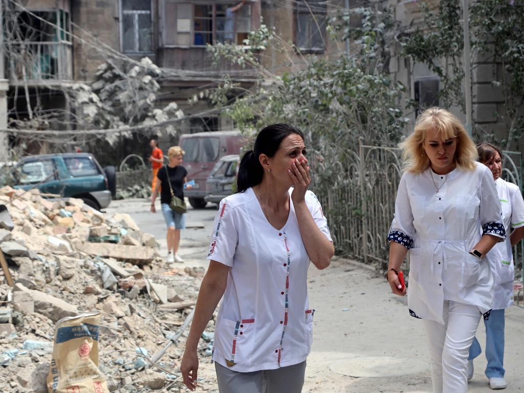 A woman reacts as she walks past a building damaged the day after a strike in Odessa. Picture: AFP