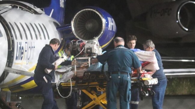 A mine worker injured in a central Queensland mine explosion is transferred to an ambulance after a LifeFlight jet touches down in Brisbane. Picture: Nathan Edwards