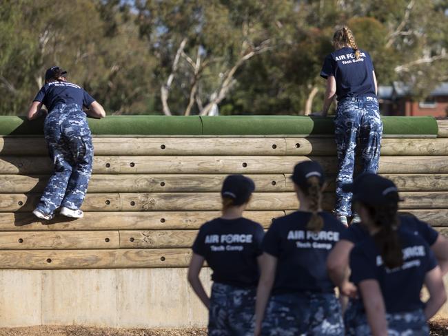 Female participants scale a wall whilst tackling a confidence course at RAAF Base Wagga.