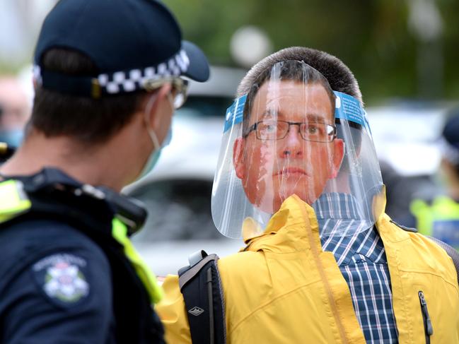 An anti-lockdown protester wearing a Daniel Andrews mask is confronted by police near the Shrine of Remembrance. Picture: Andrew Henshaw