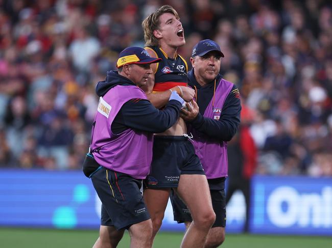 Josh Worrell in the hands of trainers. (Photo by James Elsby/AFL Photos via Getty Images)