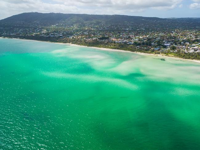 Aerial view of Rosebud pier and coastline featuring vivid turquoise bay water. Mornington Peninsula, Melbourne, Australia