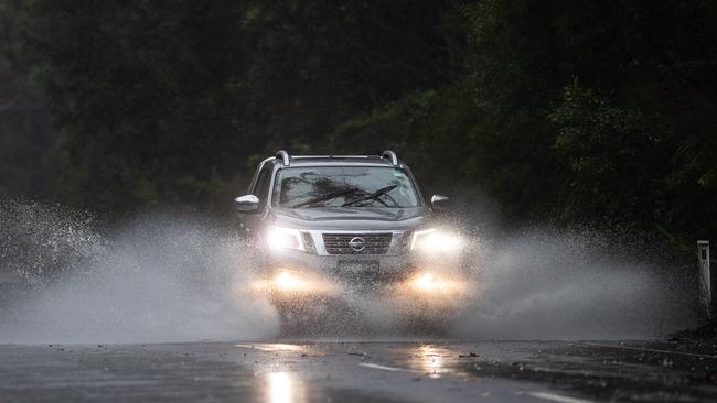 A cars slices through rainwater gathered on Wakehurst Parkway in March 2021. Pictures: Julian Andrews