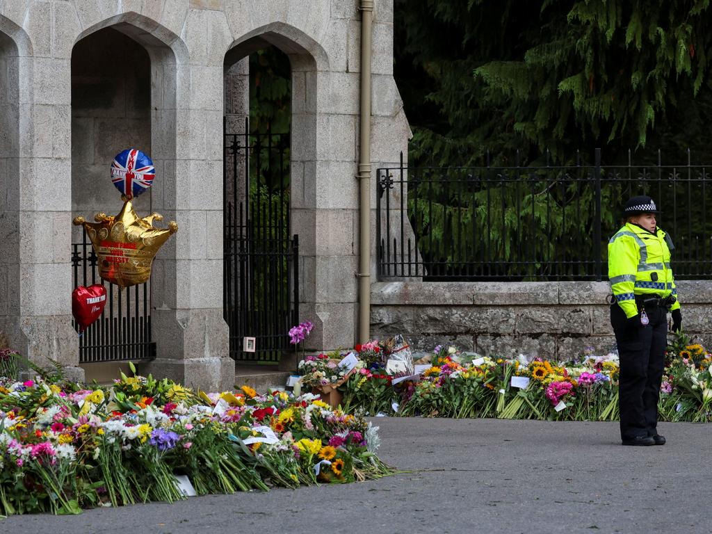 A police officer stands guard near floral tributes outside Balmoral Castle, following the passing of Britain's Queen Elizabeth, in Balmoral. Picture: Reuters.