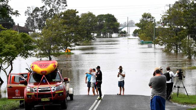 Residents stand by a flooded street in Lawrence. Photo: SAEED KHAN / AFP