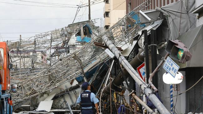 TOPSHOT - Damaged traffic boards and telecommunication relay poles are seen after they were brought down by strong winds caused by typhoon Jebi in Osaka on September 4, 2018. - The strongest typhoon to hit Japan in 25 years made landfall on September 4, the country's weather agency said, bringing violent winds and heavy rainfall that prompted evacuation warnings. (Photo by JIJI PRESS / JIJI PRESS / AFP) / Japan OUT