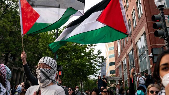 Pro-Palestinian demonstrators gather along H Street near the now fenced off University Yard at George Washington University.