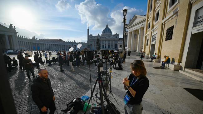 Journalists stand with the Saint Peter's Basilica in the background, following the announcement of the death of former Pope Benedict XVI at The Vatican. Picture: AFP