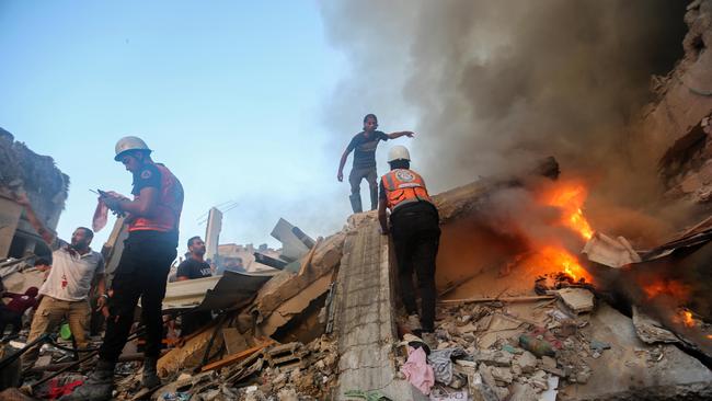 People search through buildings destroyed during Israeli air raids on Khan Yunis on Saturday. Picture: Getty Images