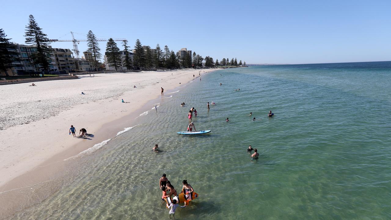 Beachgoers cooling off at Glenelg Beach. Picture: AAP Image/Kelly Barnes 