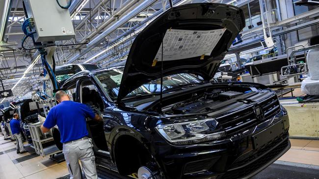 A worker fits seats on a production line at German car manufacturing giant Volkswagen's headquarters in Wolfsburg, northern Germany. Volkswagen was forced to eliminate almost all night manufacturing at the plant. Picture: AFP