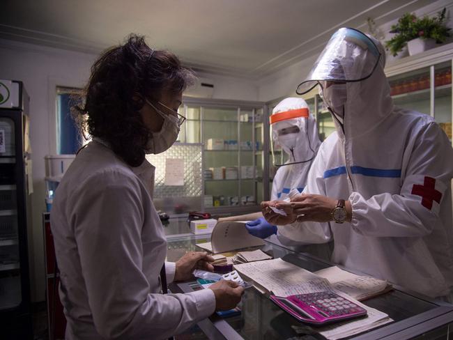 A doctor (R) from the Korean People's Army visits a pharmacy to give a woman prescription medicine in Pyongyang. Health care workers in North Korea are "intensifying" Covid tests and treatments. Picture: AFP