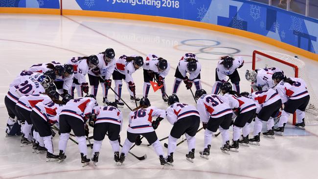 The unified Korean team gathers in a group before the women's preliminary round ice hockey match with Switzerland.