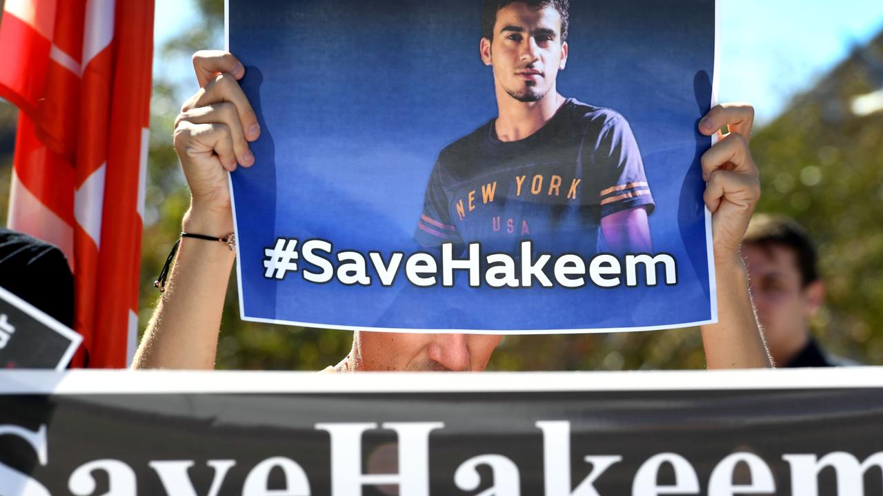 People hold up banners at a rally in Melbourne on February 2, 2019, supporting Bahraini refugee footballer Hakeem al-Araibi. Picture: William WEST / AFP.