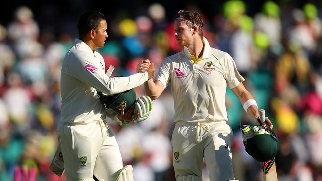 Usman Khawaja (left) and Steve Smith leave the field following the day’s play on Friday.