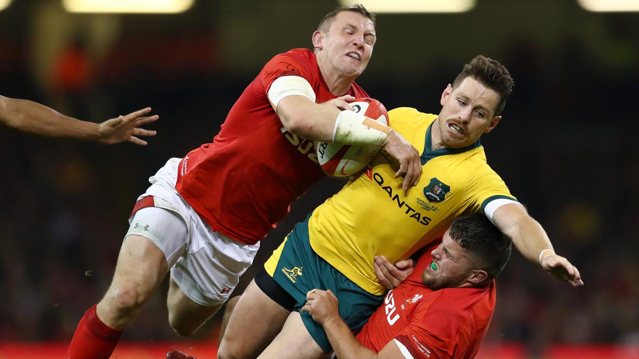 Bernard Foley of Australia is tackled by Hadleigh Parkes and Justin Tipuric of Wales.