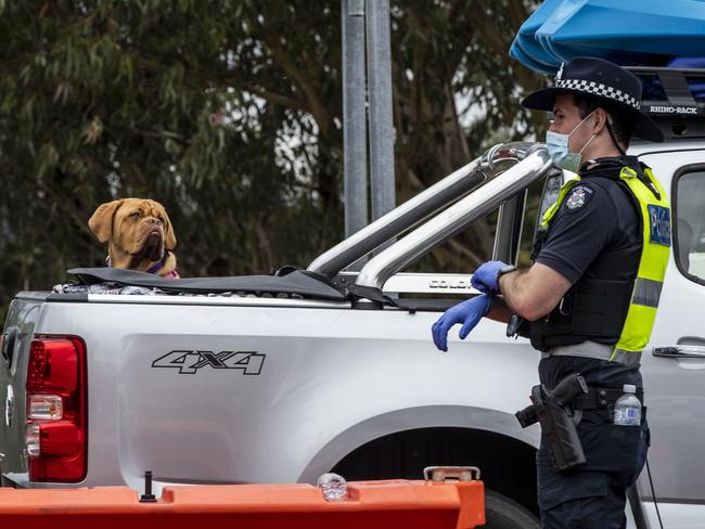 MALLACOOTA, AUSTRALIA - DECEMBER 31: A police officer watches at the Victoria border checkpoint, on December 31, 2020 in Mallacoota, Australia. Border restrictions remain in place between Victoria and New South Wales as NSW Health authorities continue to work to contain a coronavirus cluster outbreak on Sydney's Northern Beaches.  (Photo by Diego Fedele/Getty Images)